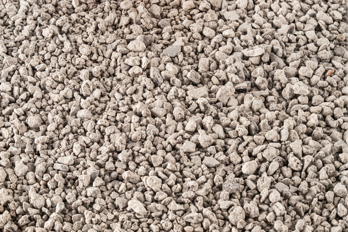 Zeolite granulare grigio chiaro, con piccoli frammenti irregolari distribuiti uniformemente su tutta la superficie.