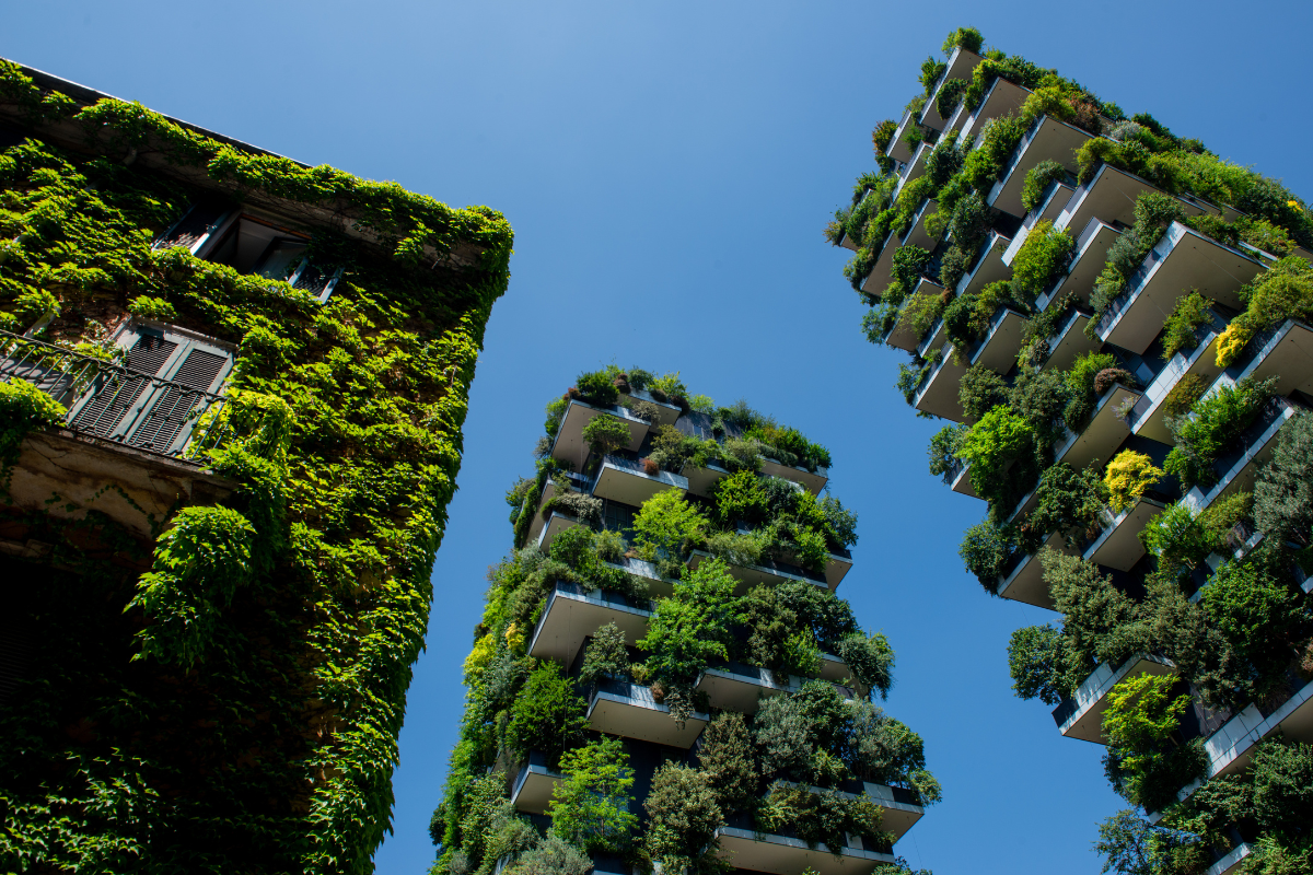 Edifici con giardini verticali e piante verdi su facciate moderne.